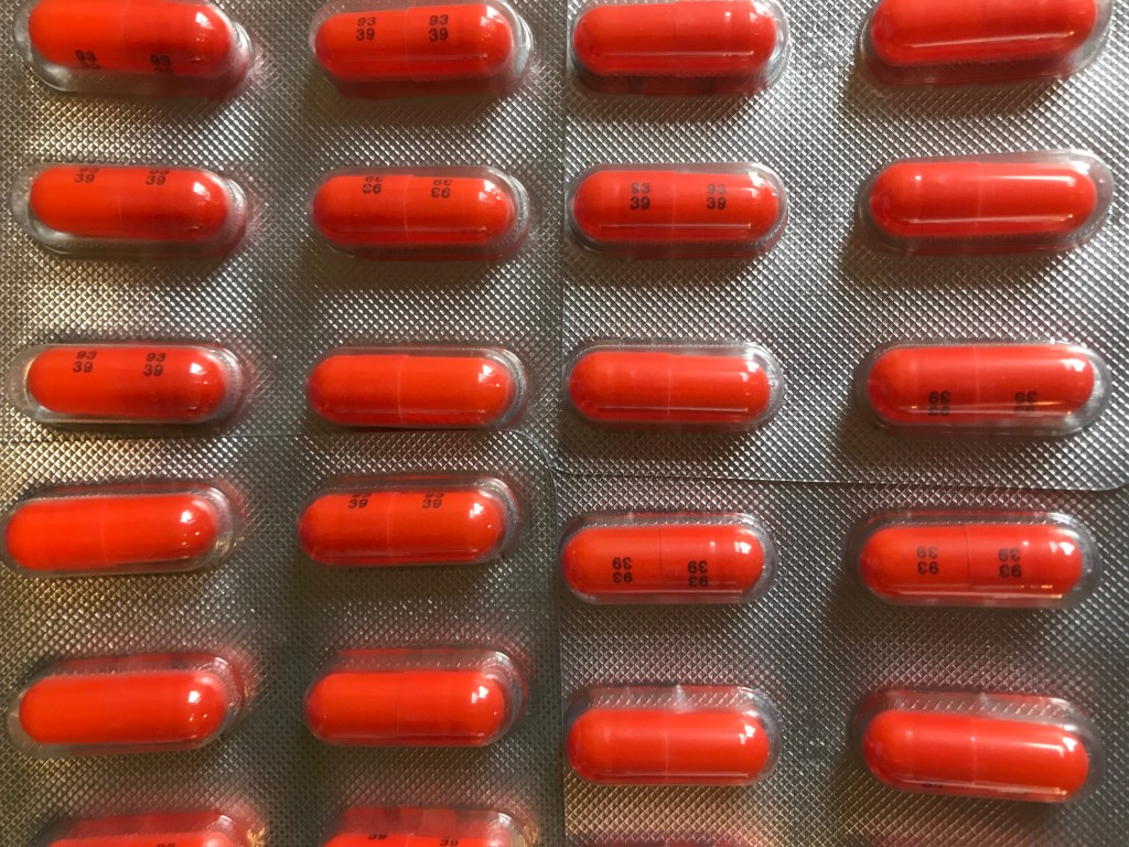 Image description: rows of orange pills in blister packs