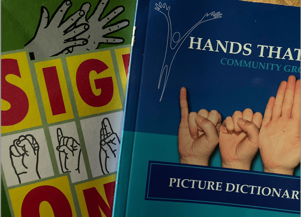 A photo showing the covers of two picture dictionaries for sign language.